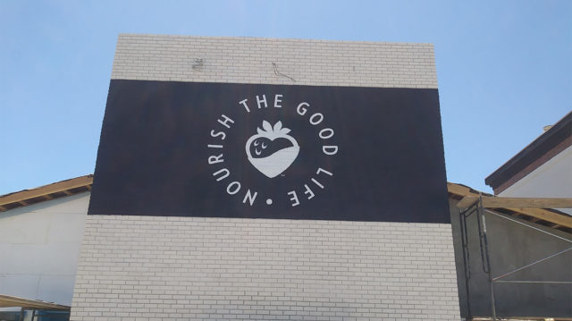 nourish the good life painted on building