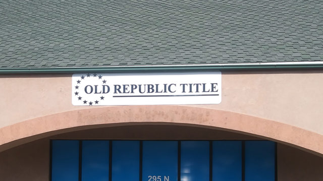 White panel with black old republic title letters on pink building
